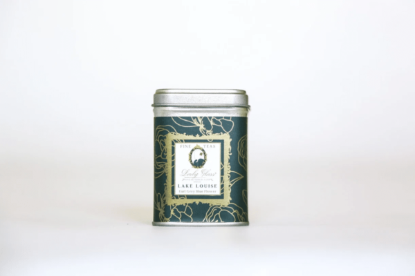 High quality loose leaf Earl Grey Blue Flower tea in a green tea caddy on a white background