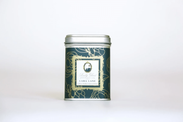 Premium loose leaf green tea in a green tea caddy and white cup on a white background