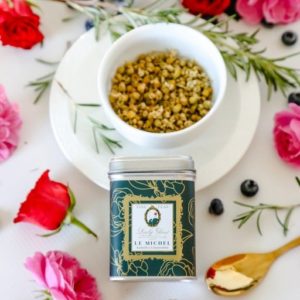 Premium whole buds chamomile tea in a green tea caddy on a white background