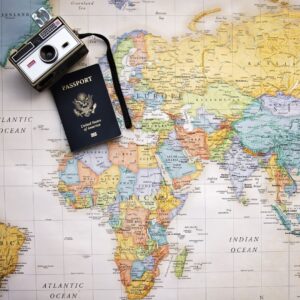 A camera and passport on top of the world map